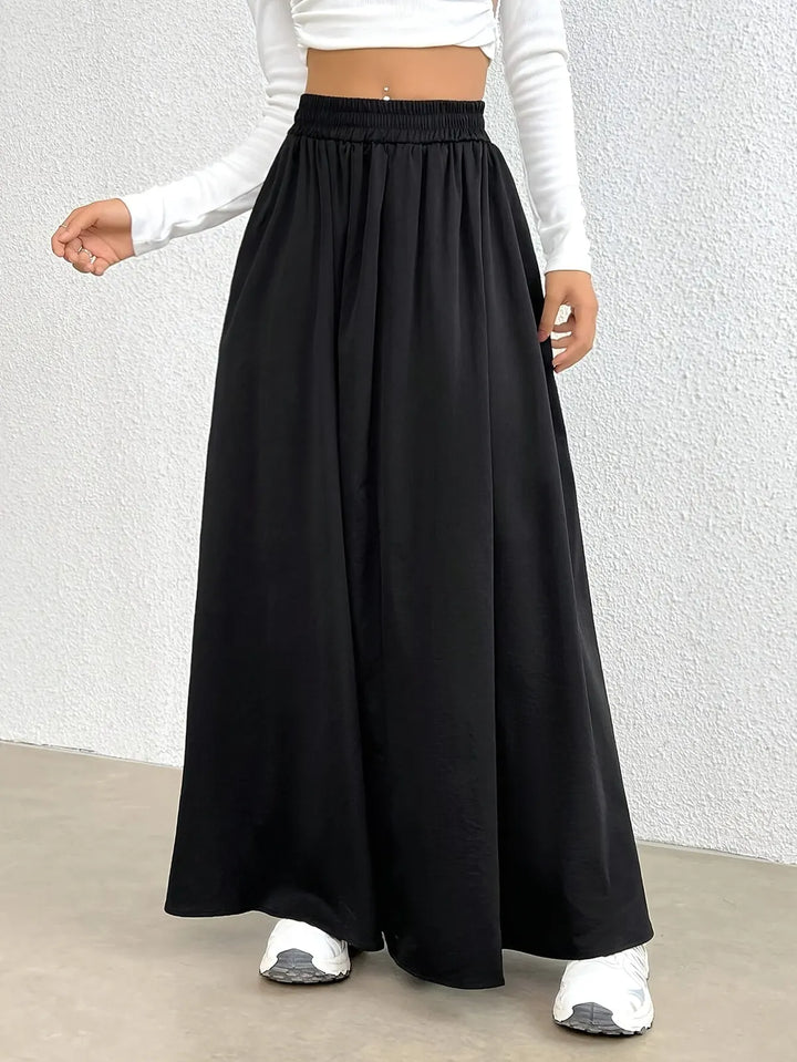 Black Women's High-Waist Flowing Black Maxi Skirt — Emerald Elastic Waist A-Line - Model Walking